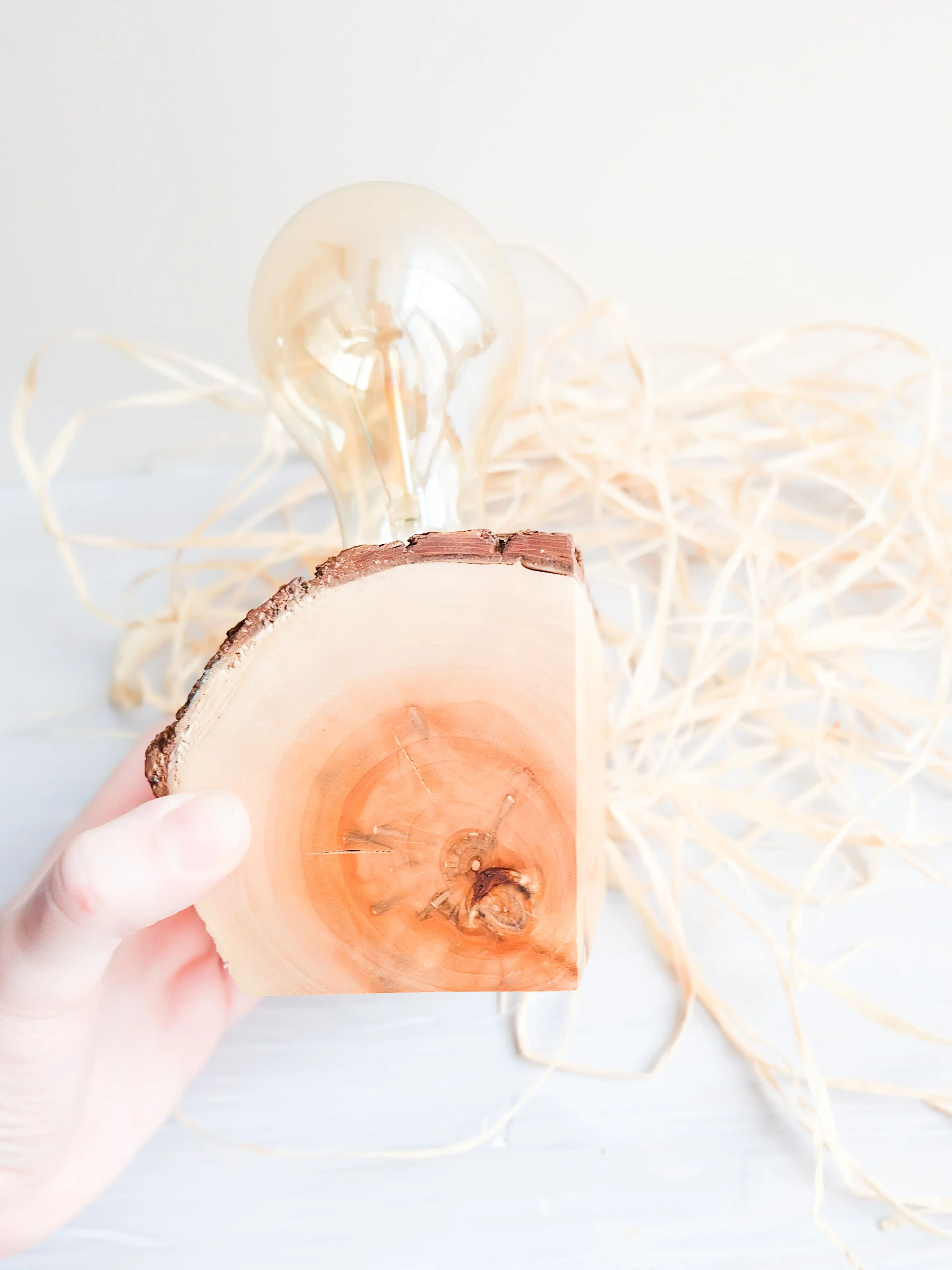 Nahaufnahme einer Hand, die ein Getränk hält, vor weißem Hintergrund.